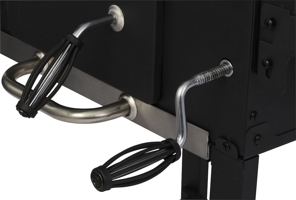 To svarte håndtak på en kullgrill i metall.