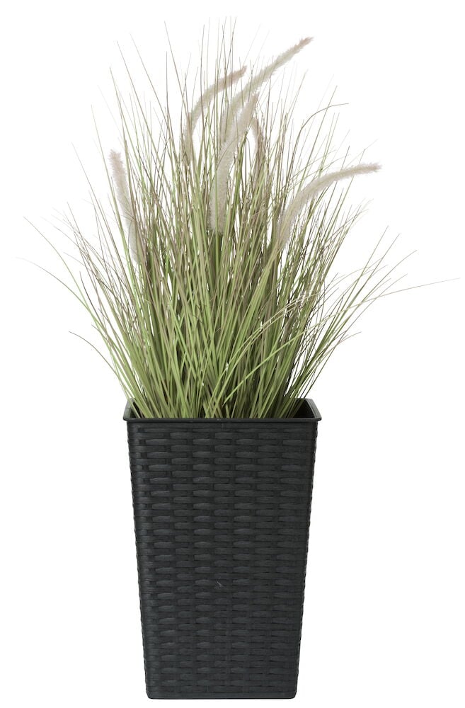 Svart hög kruka med konstväxt gräs.