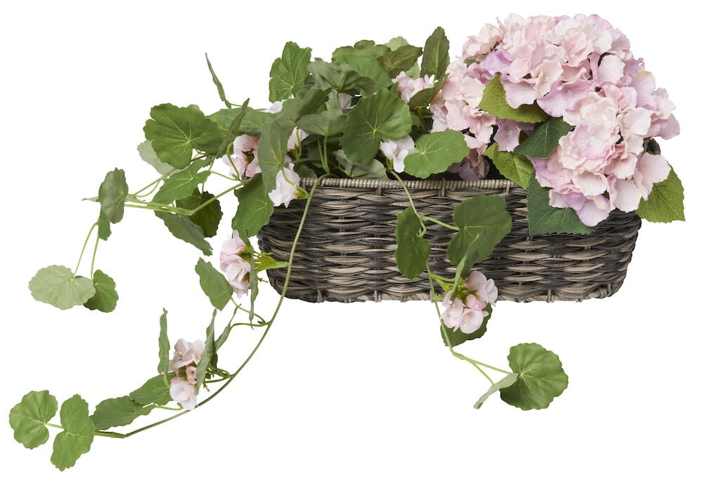 Rechteckiger Blumenkasten aus Polyrattan mit rosa Blumen.