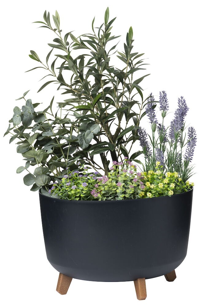 Musta ruukku, jossa puujalat ja kasveja sisällä.