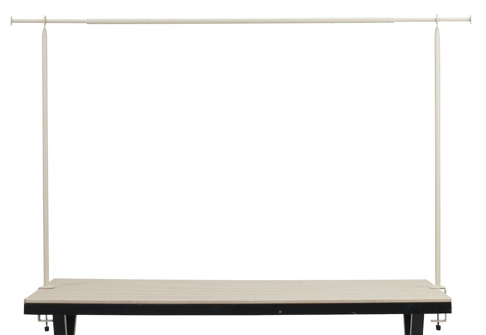 Beige dekorationsställning av stål monterad på bord.