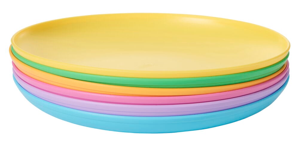 Sex färgglada plasttallrikar staplade för picknick.