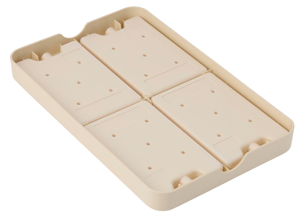 En beige Kylbricka 41x27x4 cm i plast med fyra flyttbara sektioner, var och en med små hål, sedd uppifrån.
