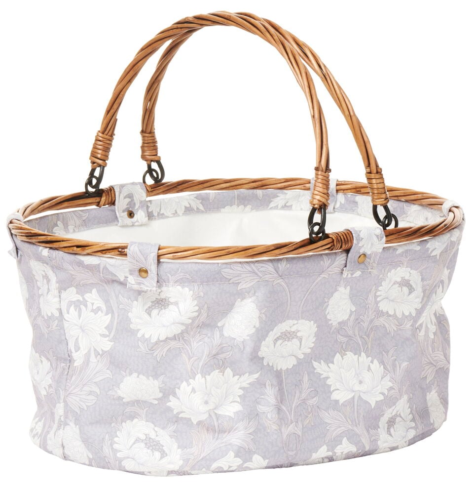 Kukkakuvioinen taitettava piknikkori rottinkikahvalla.