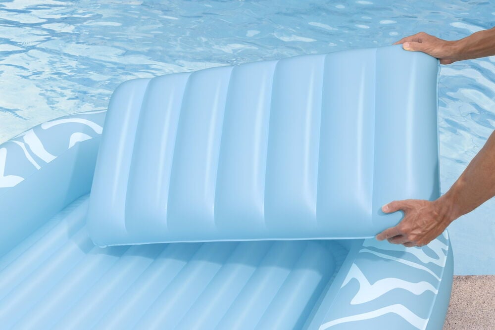Blå uppblåsbar solsäng med avtagbar kudde vid pool.