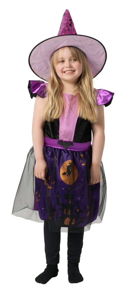 En flicka bär en lila och svart häxdräkt: hatt, klänning med spökhusmotiv, leggings och strumpor.