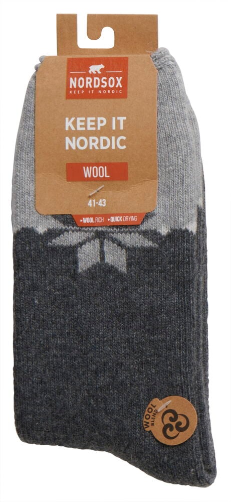 Harmaa villasukka tähtikuviolla ja etiketillä.