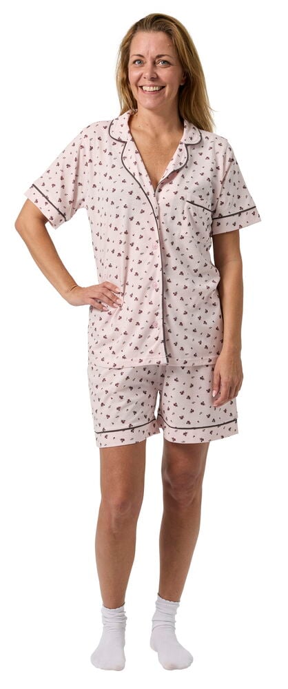 Kvinne bærer Pysjamas Klara Blandede farger, rosa mønstret kortermet topp og shorts, med hvite sokker.