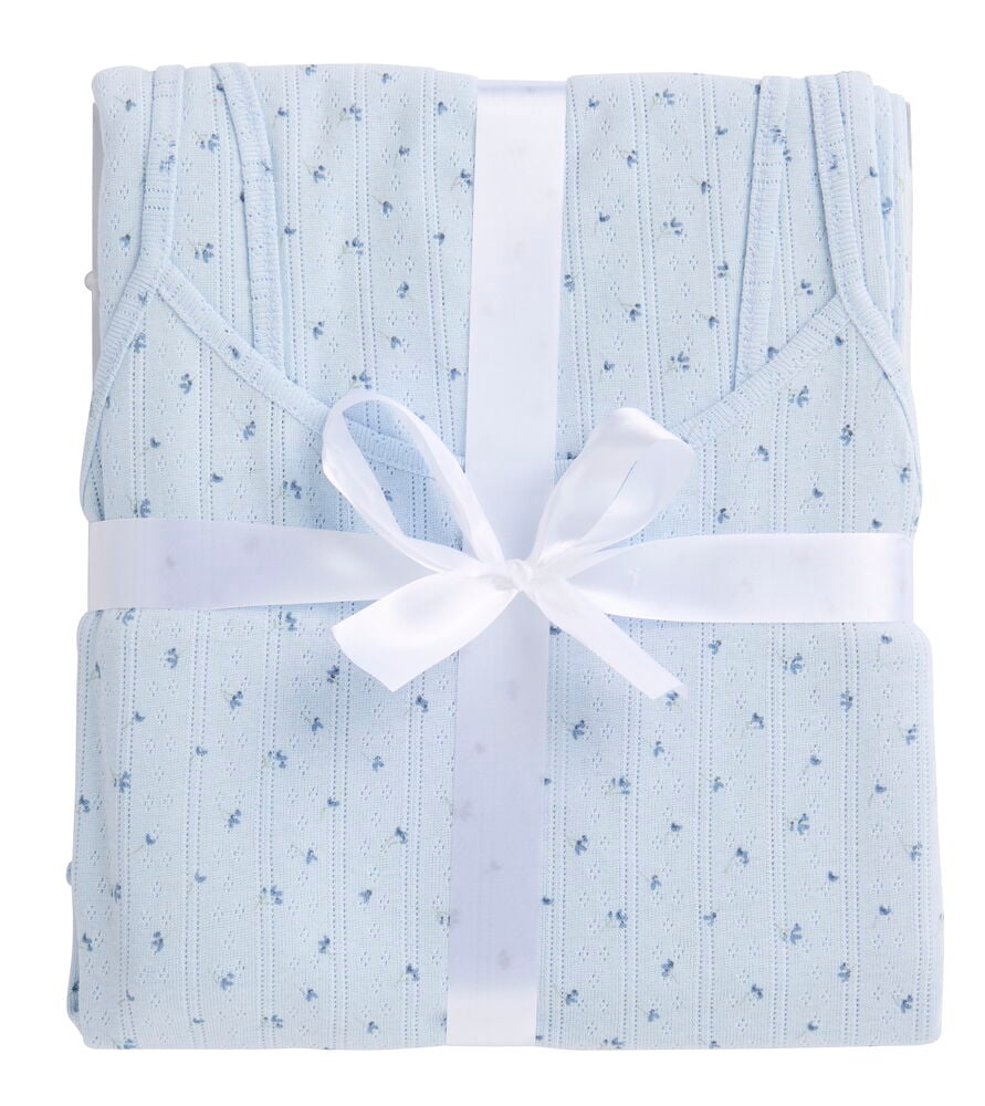 Ljusblå baby Pyjamas Polly-set med små blommönster, knutet med vitt band.