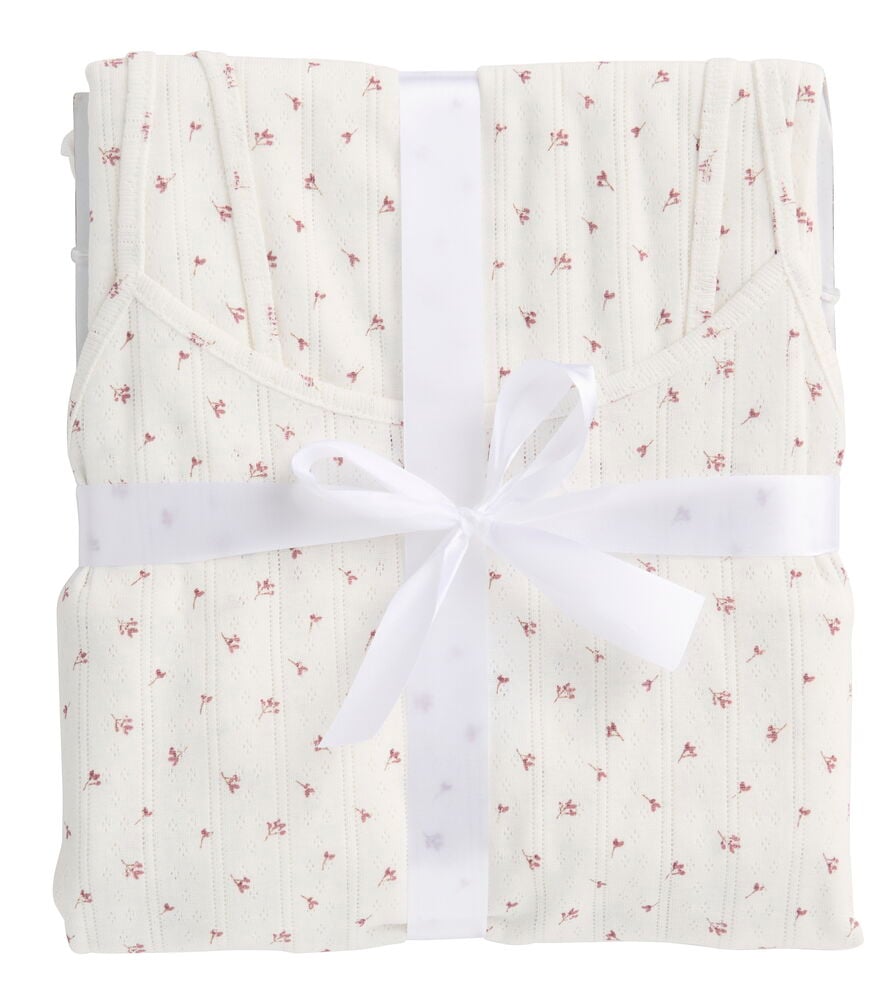 Vikt Pyjamas Polly-set med vit ribbad blommönstrad topp och byxor, knutet med vitt band.