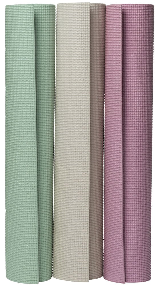 Tre yogamattor i olika färger upprullade stående.