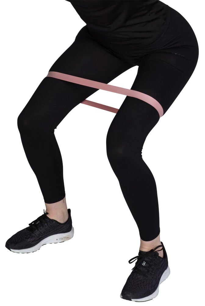 Rosa Mini-Widerstandsbänder von einer Person getragen, mit schwarzen Leggings und Sportschuhen.