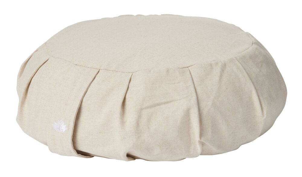 Pyöreä beige meditaatiotyyny, jossa kantokahva.