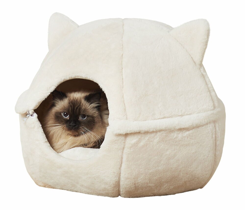 Ljus kattbädd i plysch med katt inuti.