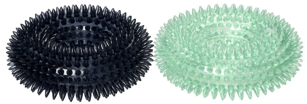 Två runda taggiga hundleksaker i olika färger.