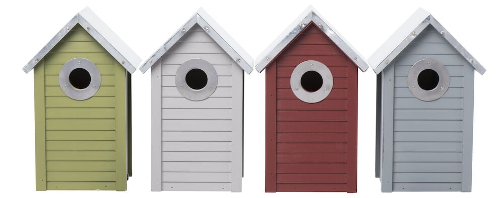 Neljä linnunpönttöä eri väreissä peltikatolla.