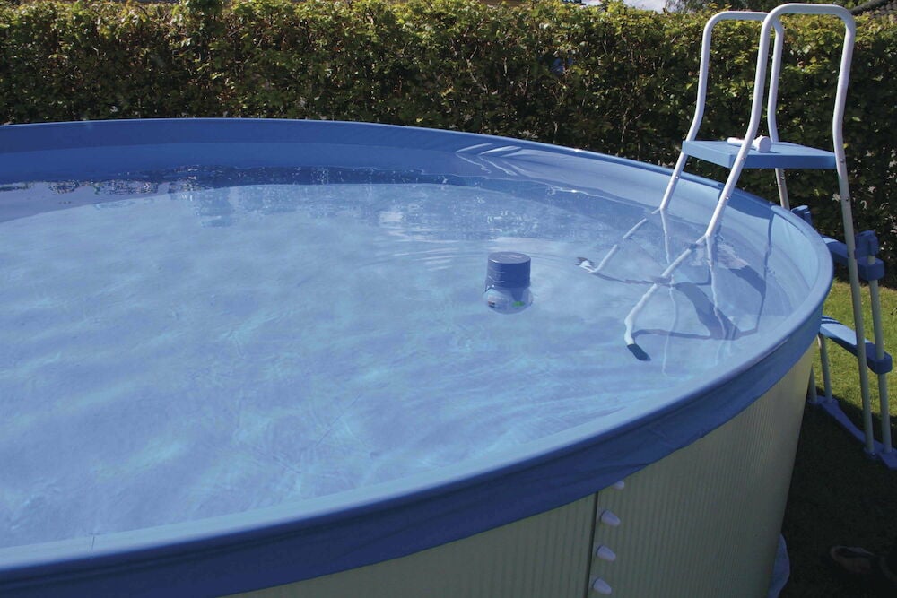 Rund ovanmarkspool med stege och dispenser i vattnet.