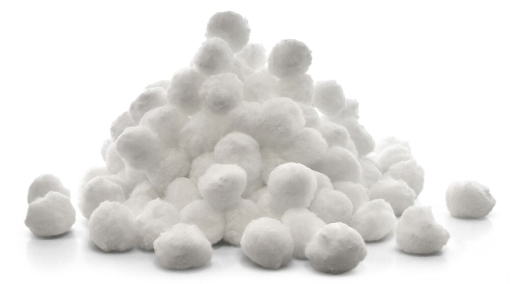 En hög vita filterbollar för poolrengöring.