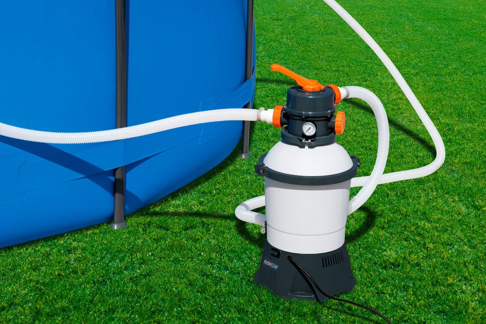 Sandfilterpumpe 3028 Liter GS, weiß und dunkelgrau, mit weißen Schläuchen an einen blauen Pool angeschlossen.