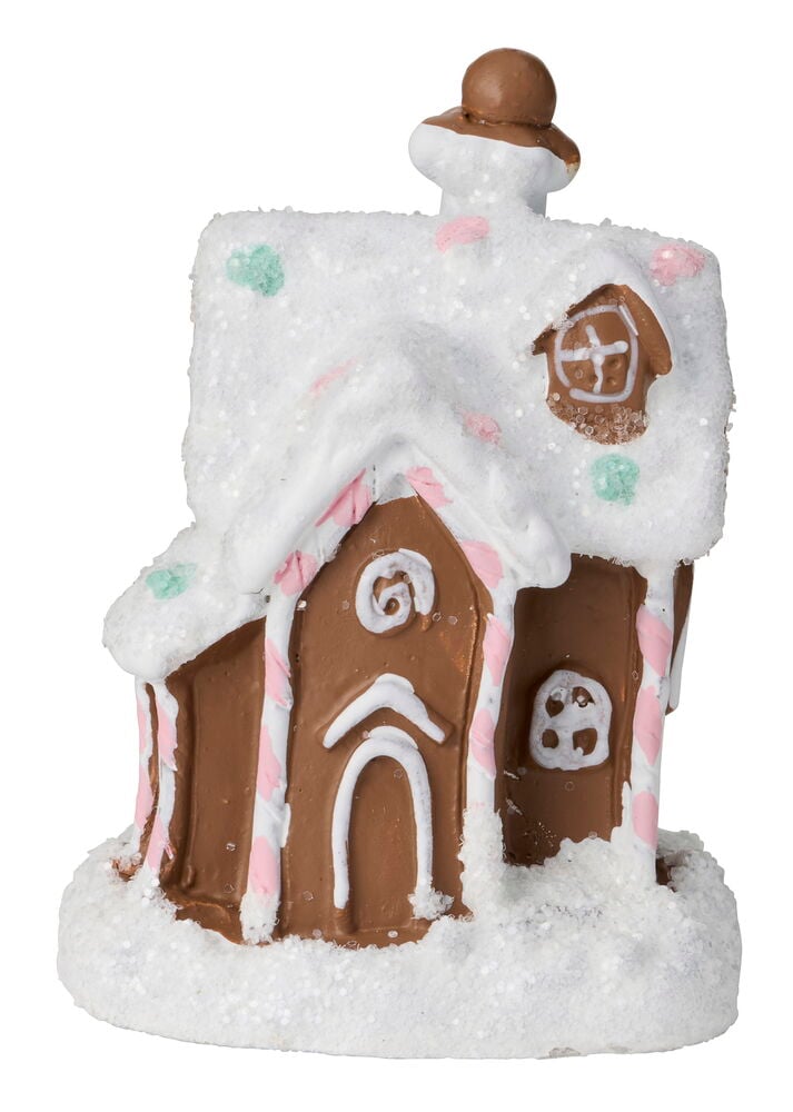 Julig betongdekorationsfigur formad som ett pepparkakshus med vit snö, rosa/gröna godisar och glasyrdetaljer.