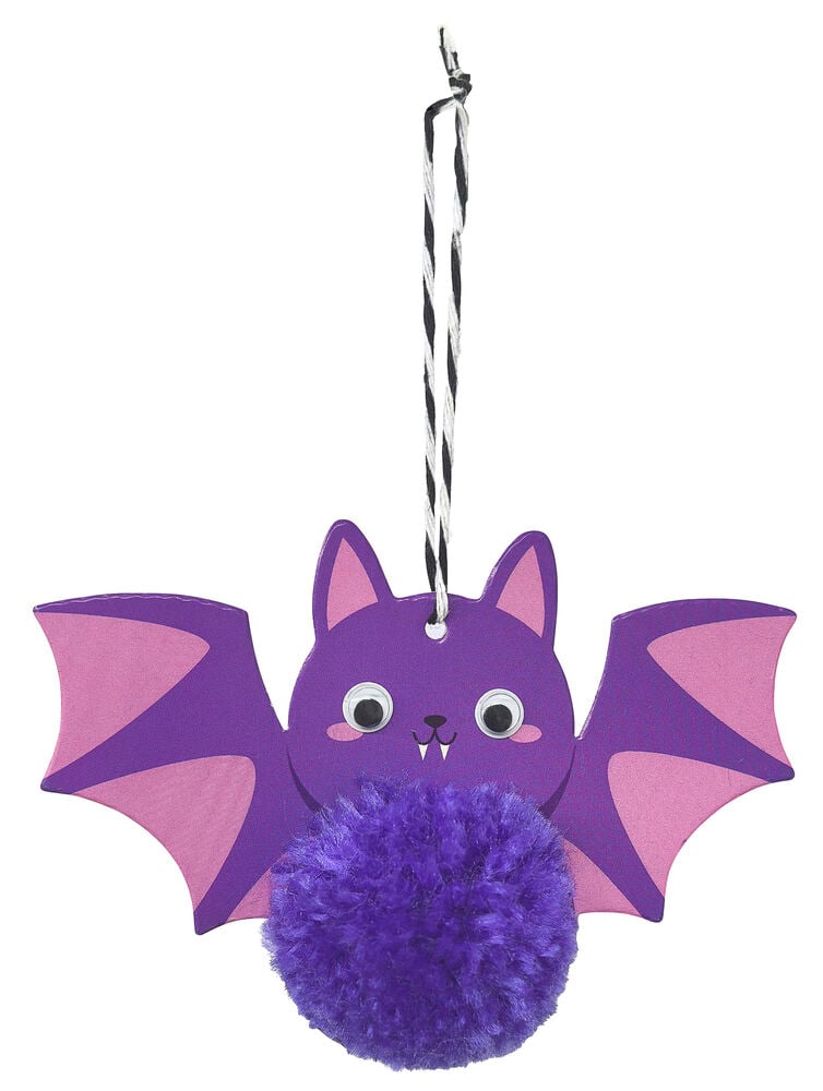 Eine lila Halloween-Fledermausdekoration mit rosa Flügeln, Wackelaugen, Fangzähnen und lila Bommel-Körper, hängend.