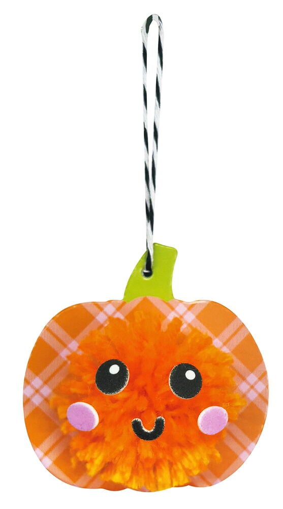 Ein hängender orangefarbener Karo-Kürbis aus dem Bommel-Bastelset, mit flauschigem Gesicht, Wackelaugen und rosa Wangen.