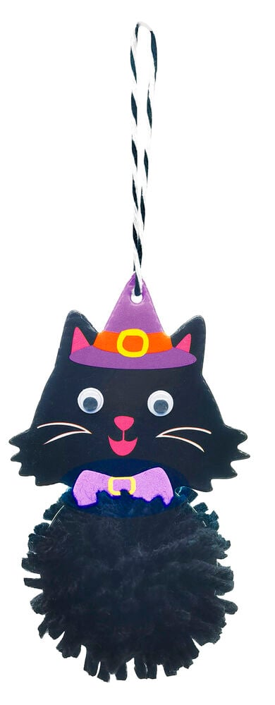 Ein schwarzes Katzen-Halloween-Ornament aus dem Bommel-Bastelset, mit lila Hexenhut und Wackelaugen.