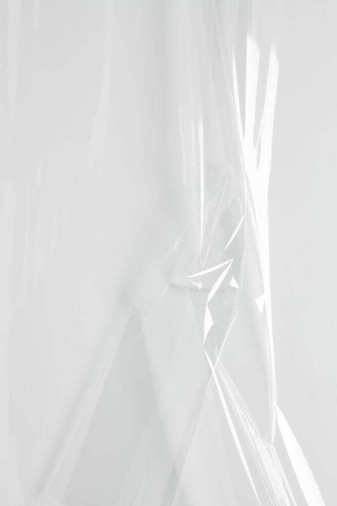 Läpinäkyvä sellofaanimuovi taitettuna valkoista taustaa vasten.