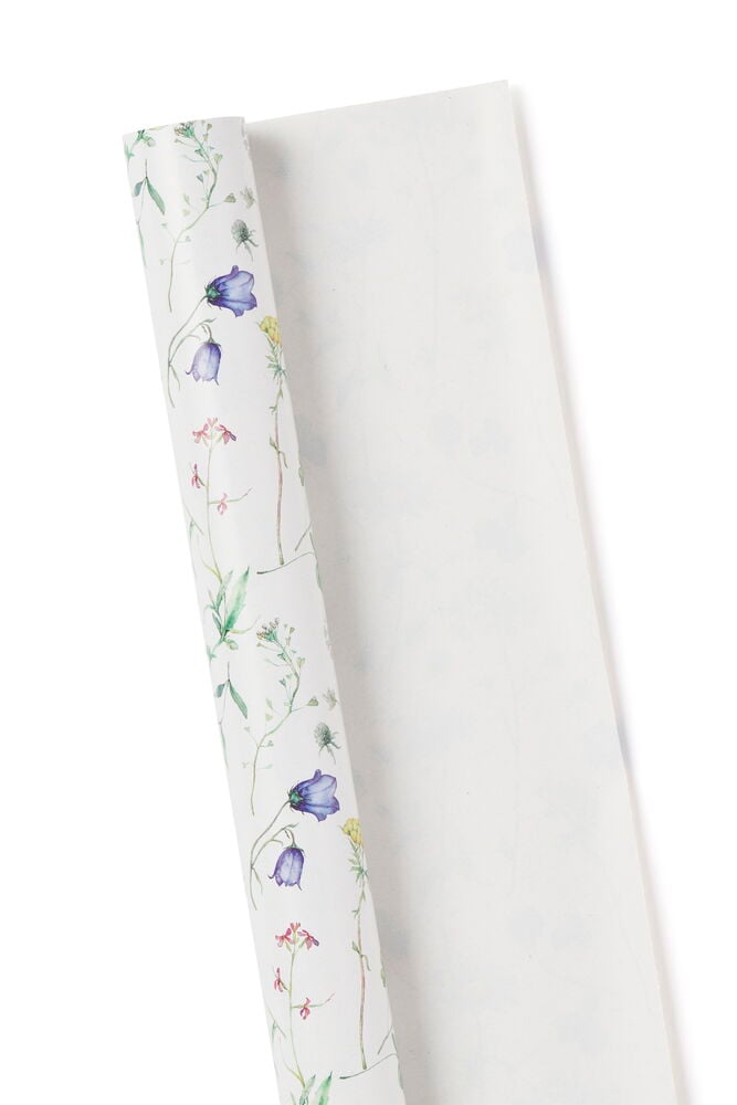 Vitt presentpapper med blommönster utrullat på vit bakgrund.