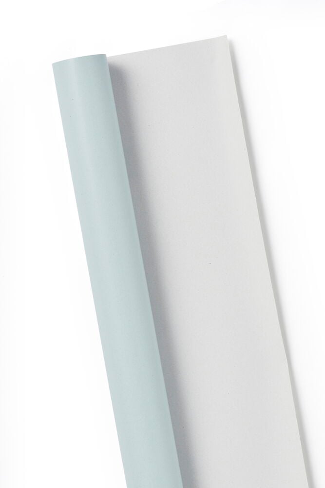 En rulle ljusgrönt presentpapper mot vit bakgrund.