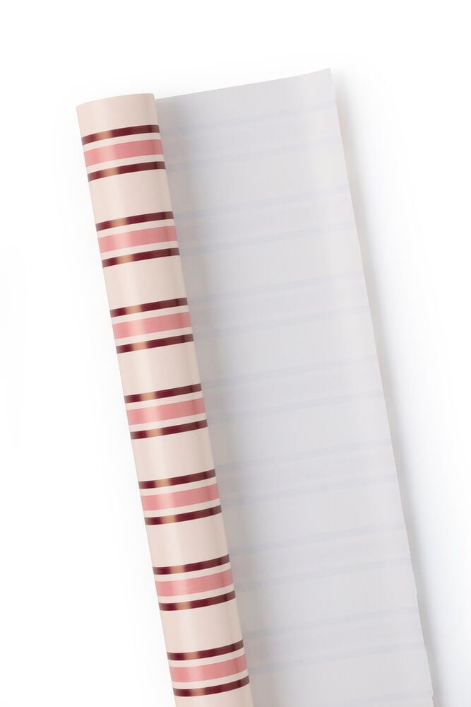 En rull julepapir med rosa og brune horisontale striper, delvis utrullet.