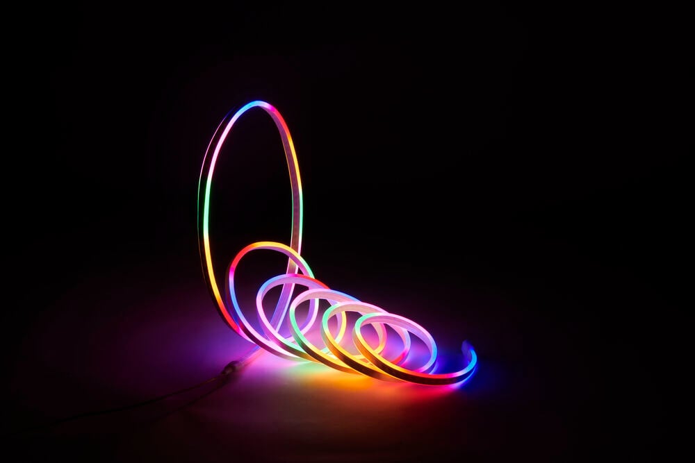 Monivärinen Neon Valoketju valaistussa, kiertyneessä koristeellisessa muodossa.