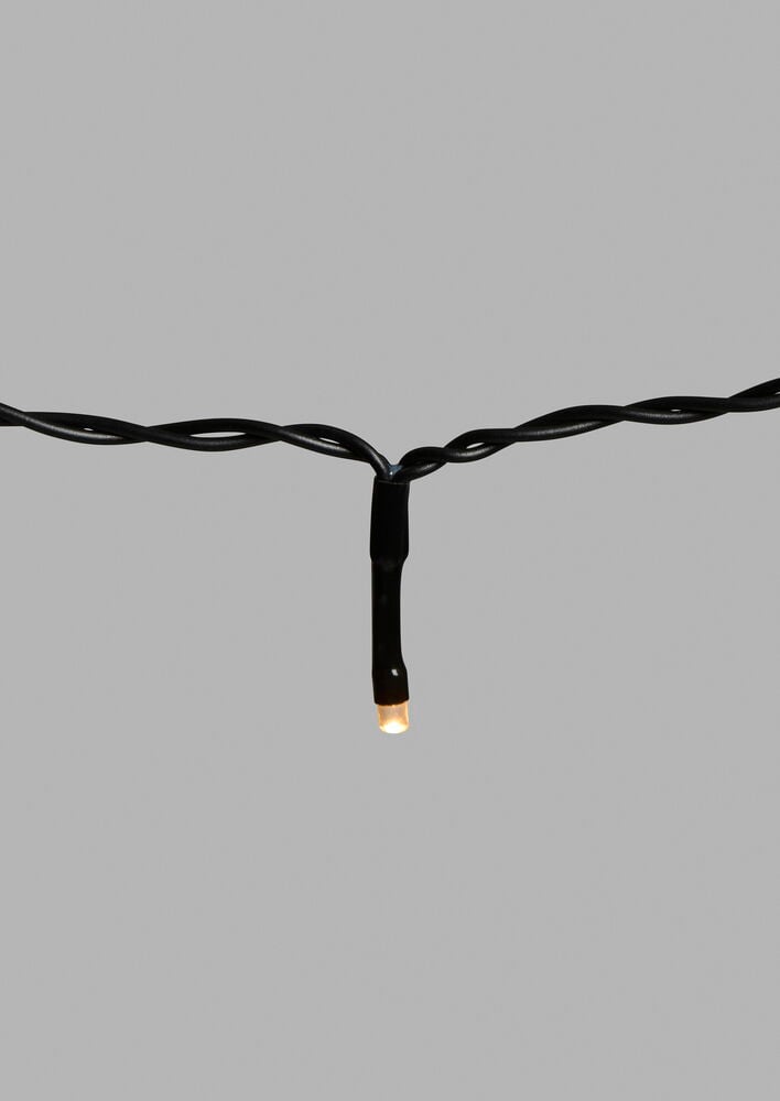 Närbild av svart Ljusslinga Glänsa 8 m, 81 LED Varmvit med en tänd varmvit LED.