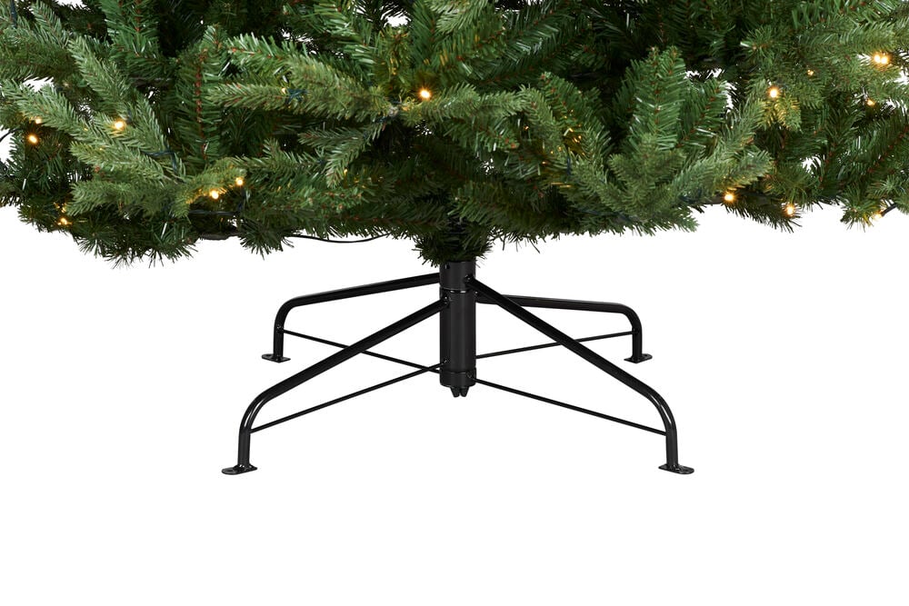 Juletre Chamonix PVC/PE 302 LED med grønne grener, varme lys og en svart metallfot.