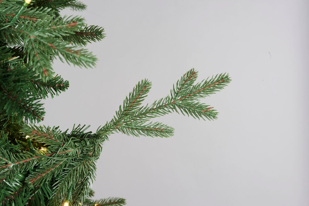Nærbilde av grønne kunstige Juletre Chamonix PVC/PE 456 LED-grener med varmhvite lys.