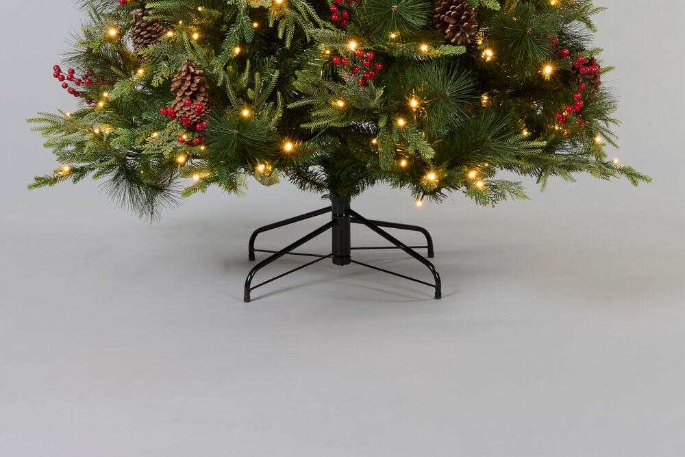 Juletre Engelberg 210 cm PVC/PE 360 LED har grønne grener, kongler, røde bær, LED-lys og står på en svart metallfot.