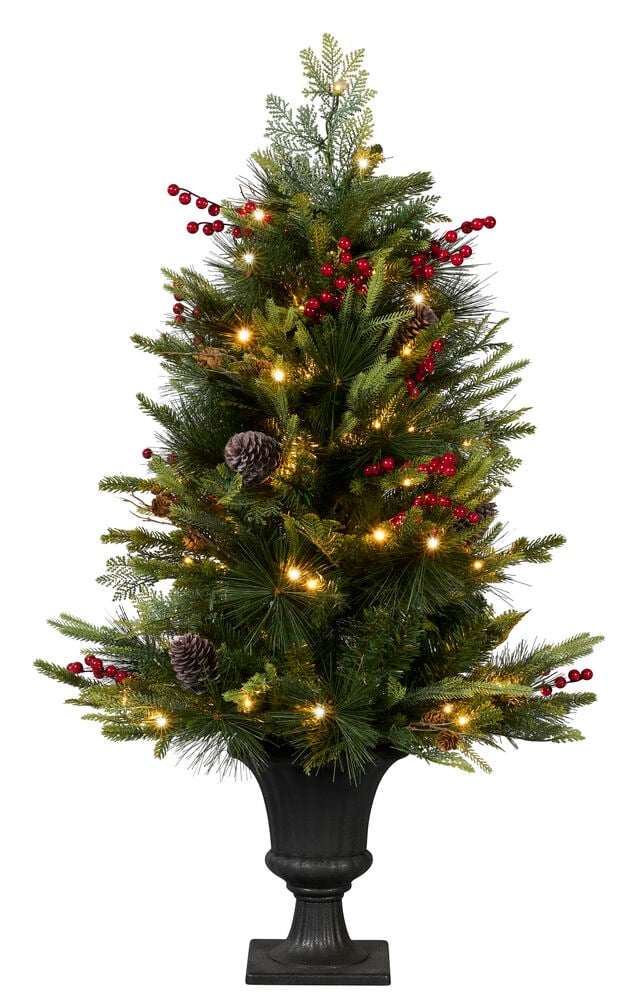 Grønn Pyntegran Engelberg 110 cm med varmhvite LED-lys, røde bær og kongler i en svart urne.