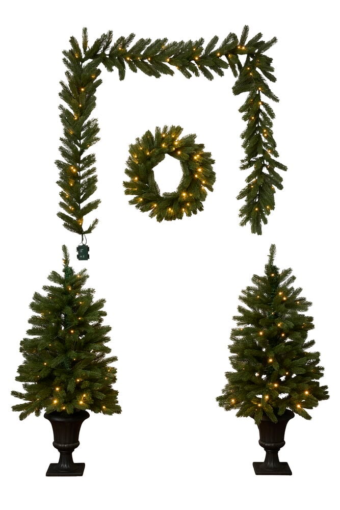 Juldekorationer set 4 delar Med LED-belysning: girlang, krans, och två mörkgröna krukträd.