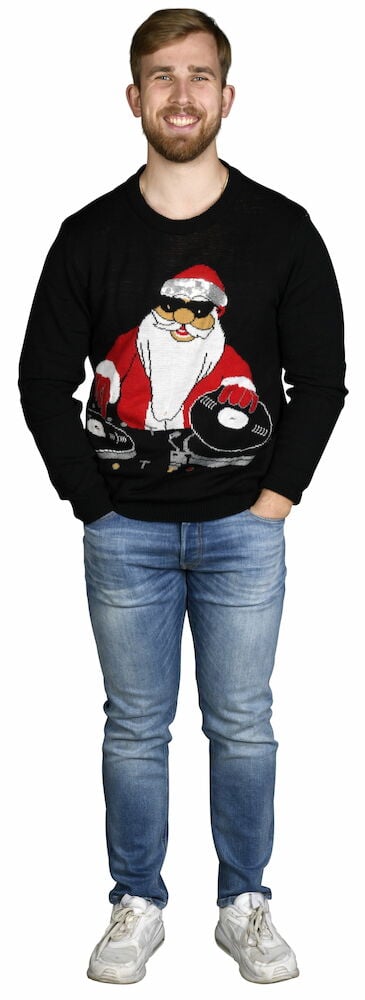 En mann bærer en svart Disco Santa julegenser, blå jeans og hvite joggesko, med hendene i lommene.