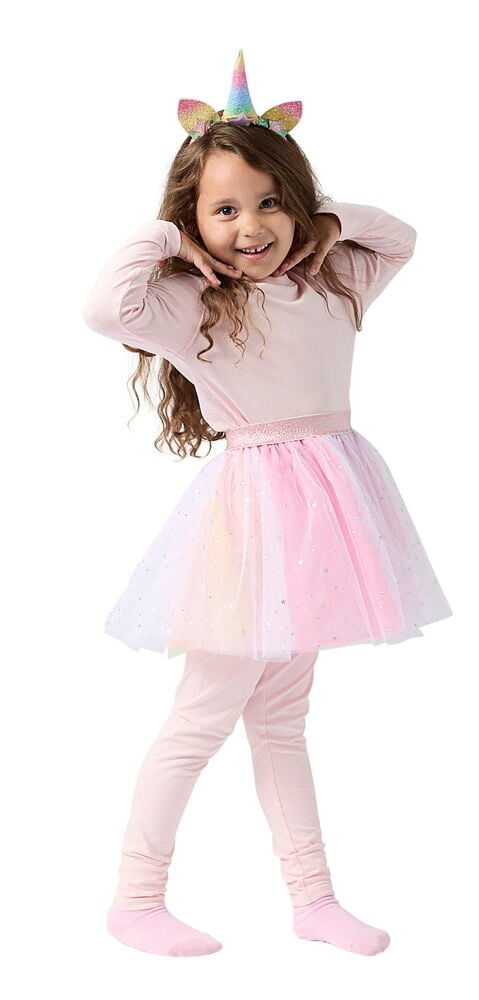 Ein Kind trägt ein Verkleidungsset mit regenbogenfarbenem Einhorn-Haarreif, pinkem Langarm-Top, glitzerndem Tüllrock und pinken Leggings.