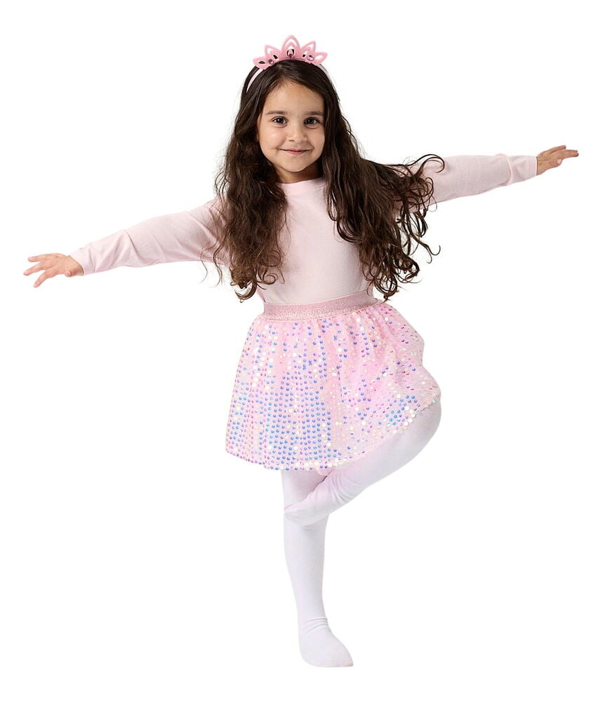 Verkleidungsset, Kinder: Kind trägt rosa Langarmshirt, Paillettenrock, weiße Strumpfhose und rosa Krone.