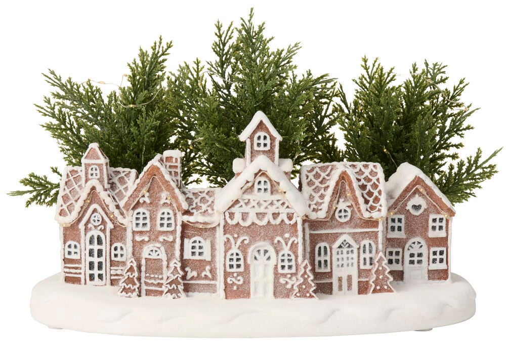 Lebkuchenhausdorf Dekoration mit weißem Schnee, grünen Bäumen und warmweißen batteriebetriebenen Lichtern mit Timer.