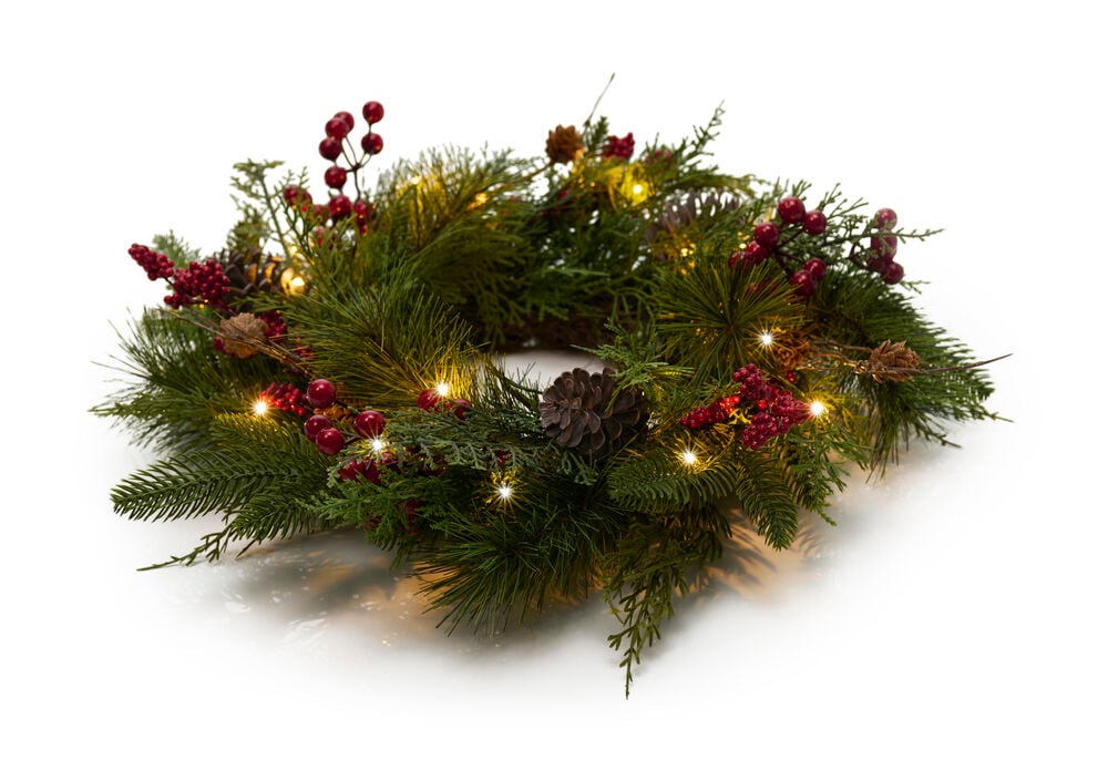 Weihnachtskranz aus grünen Tannennadeln mit roten Beeren, Tannenzapfen und Warmweiß Batteriebetrieben mit Timer-Lichtern.