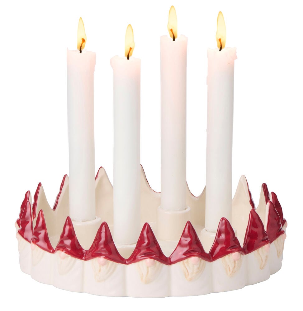 Valkoinen keraaminen adventtikynttelikkö punaisilla tontuilla, pitäen neljää palavaa valkoista kynttilää.