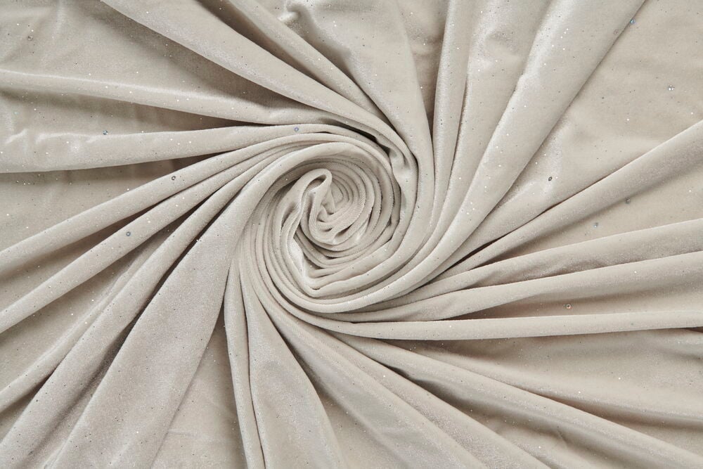 Beiger Polyestersamt Funkeln Vorhang, spiralförmig drapiert, zeigt seine Textur und Glanz.