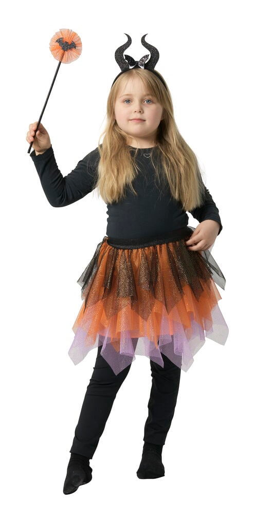 Barn bär Maskeradset, barn: skiktad orange/svart/lila tyllkjol, svart glitter horn pannband, håller stav. Svart tröja, leggings.