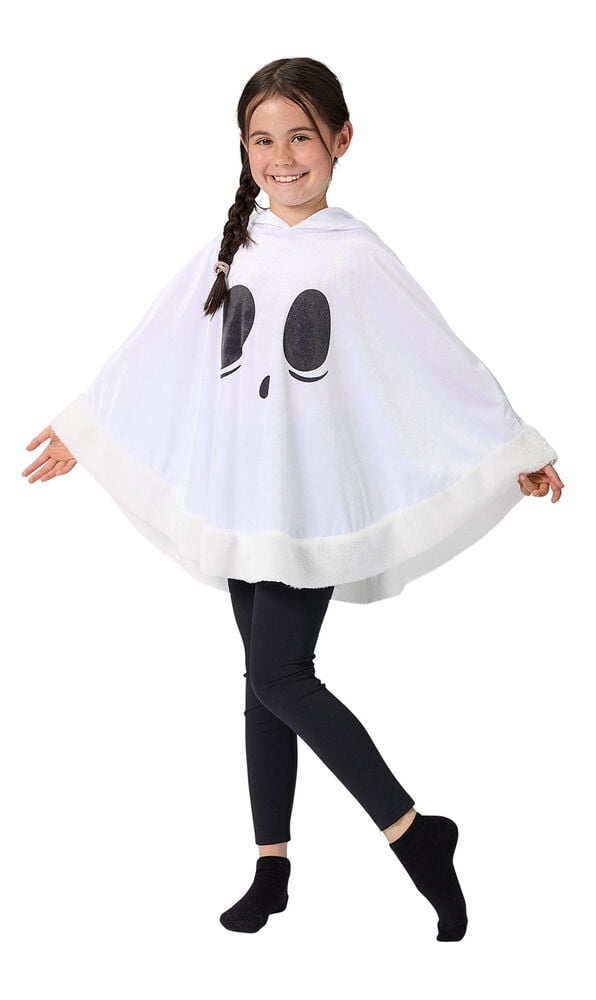 Vit Poncho, barn Halloween med svart spökansikte och luddig kant, bärs av ett barn med svarta leggings och strumpor.