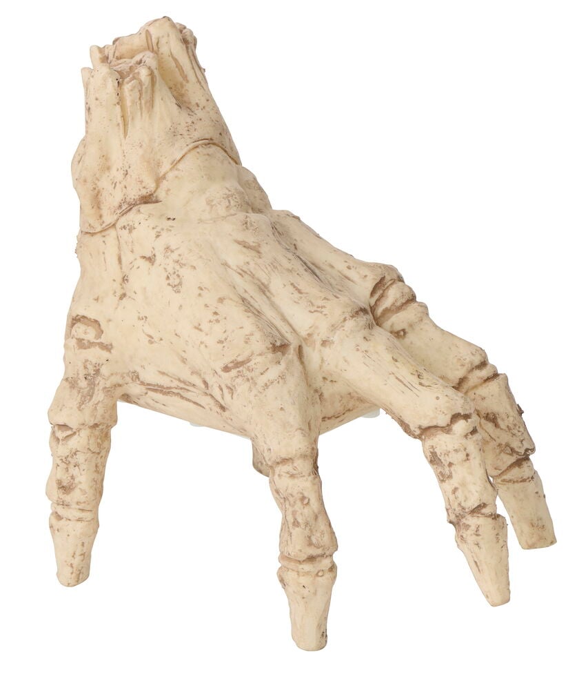 Eine knochenfarbene, verwitterte Handskulptur.