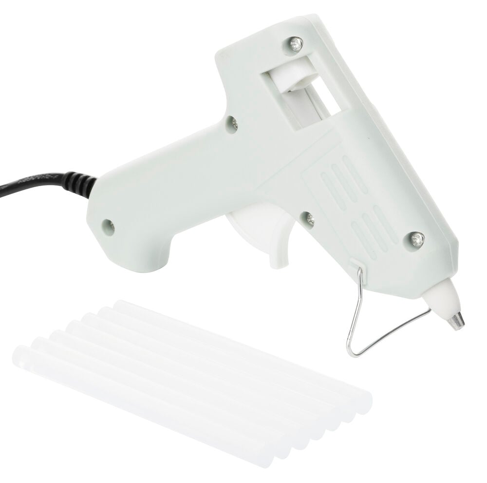 En lys grå Limpistol med hvit avtrekker og metallstativ, tilkoblet en svart ledning, samt flere gjennomsiktige hvite limstifter.