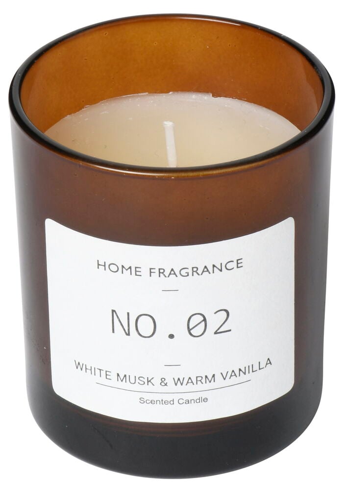 Brunt doftljus i glas med vit etikett.